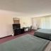 Knights Inn Kirksville guest room with two beds, desk, TV, and sliding glass door in Kirksville