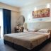Alexandros Boutique Hotel in Náfplio guest room with king bed, sofa, and balcony curtains