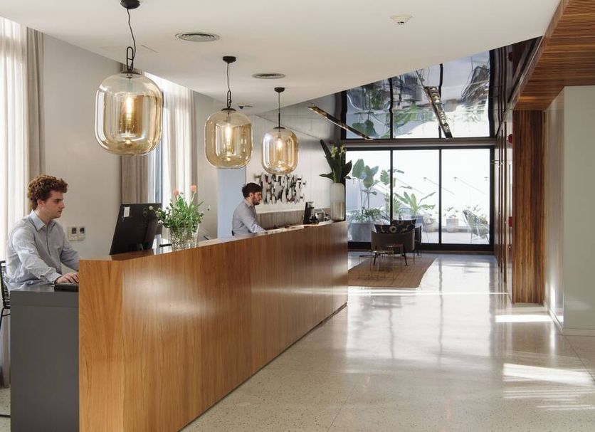 Krista Boutique Hotel Buenos Aires lobby with wood reception desk and hanging pendant lights