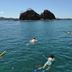 CC Beach Front Hotel in Playa Hermosa with snorkelers in clear blue ocean by rocky islets