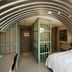 823 Tourist Hotel in Jinhu Township room with arched metal ceiling, white bed, and glass partition