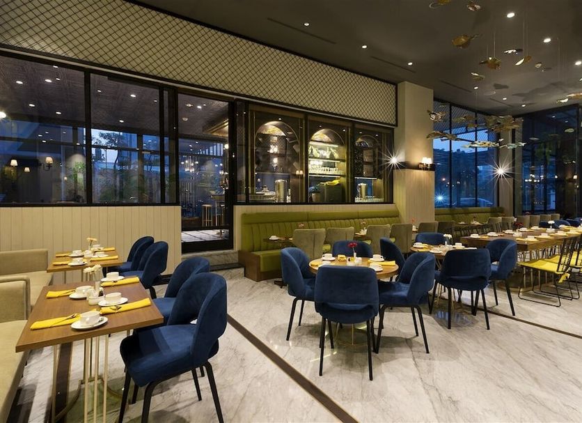 Aviary Bintaro restaurant in South Tangerang City with blue chairs, set tables, and large windows
