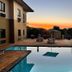 Hampshire Hotel - Ballito pool terrace at sunset with lounge chairs and picnic tables in Ballito