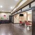 Quality Inn West Plano - Dallas in Plano: breakfast area with counters, tables, chairs, and TV