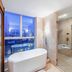 Shengshi Civil Aviation Hotel in Zhengzhou bathroom with soaking tub, glass shower and city view
