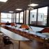 Le Grand Hotel in Maubeuge conference room with long meeting tables and chairs beside large windows