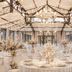 Château De Noirieux in Briollay: elegant glass-roofed banquet hall with round dining tables and chandeliers