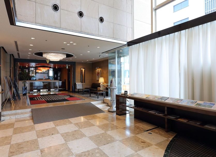 Apa Hotel Takaoka Marunouchi lobby in Takaoka with check-in desk, seating area and tiled floor
