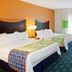 Fairfield Inn & Suites by Marriott Lewisburg guest room with two beds, desk, and colorful carpet