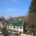 Haus Wartenberg in Salzburg with a green-roofed building, trees, and clear blue sky