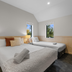 Tasman Holiday Parks - Christchurch bedroom with two beds, bedside lamps and windows