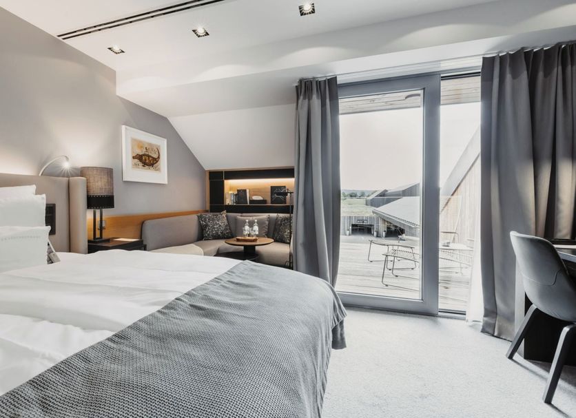 Der Öschberghof in Donaueschingen bedroom with balcony doors to a terrace and golf course view