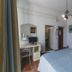 Hotel Alfiero in Porto Santo Stefano bedroom with bed, desk, wardrobe, mirror and ceiling light