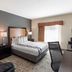 Best Western Inn & Suites - Midway Airport guest room with king bed, desk, armchair and window in Burbank