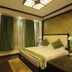 Hotel Dip Palace, Darjeeling guest room with king bed, green curtains, wall-mounted TV and patterned accent wall