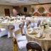 Sleep Inn Sea Tac Airport banquet room with round tables, white chair covers and decorated stage