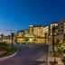 Hilton Skanes Monastir Beach Resort in Monastir at dusk, with illuminated resort exterior and palm-lined drive