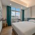 Qunxian Hotel Guangzhou guest room with double bed, city view window, and teal curtains