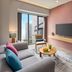 Novotel Living Saigon South in Ho Chi Minh City guest room with city view, sofa, TV and bedroom doorway