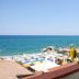 Hotel Il Gabbiano Beach in Terme Vigliatore with sea view, beach umbrellas and sunflowers on a balcony