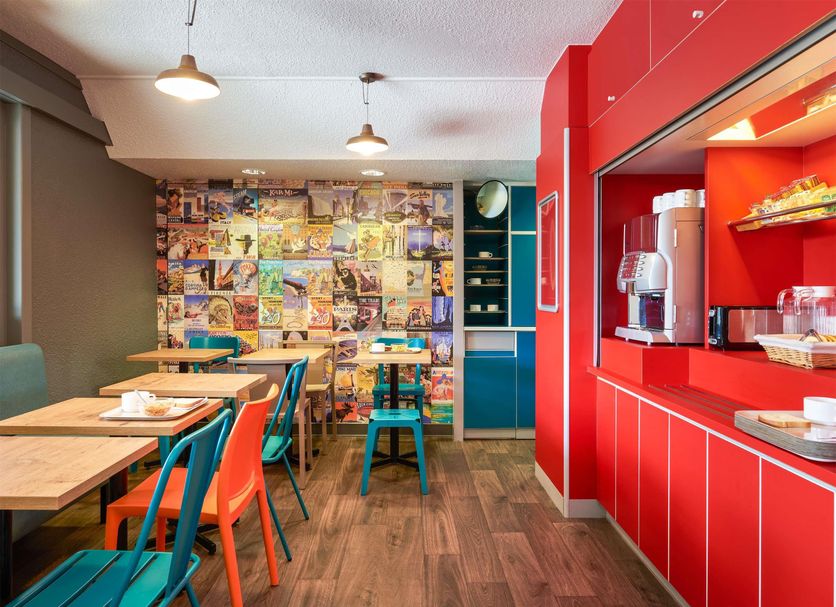 Hotelf1 Orange Centre Echangeur A7 A9 breakfast room with colorful chairs and red coffee station