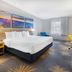 Days Inn Roanoke Near I-81 guest room with king bed, colorful wall art, TV, and window