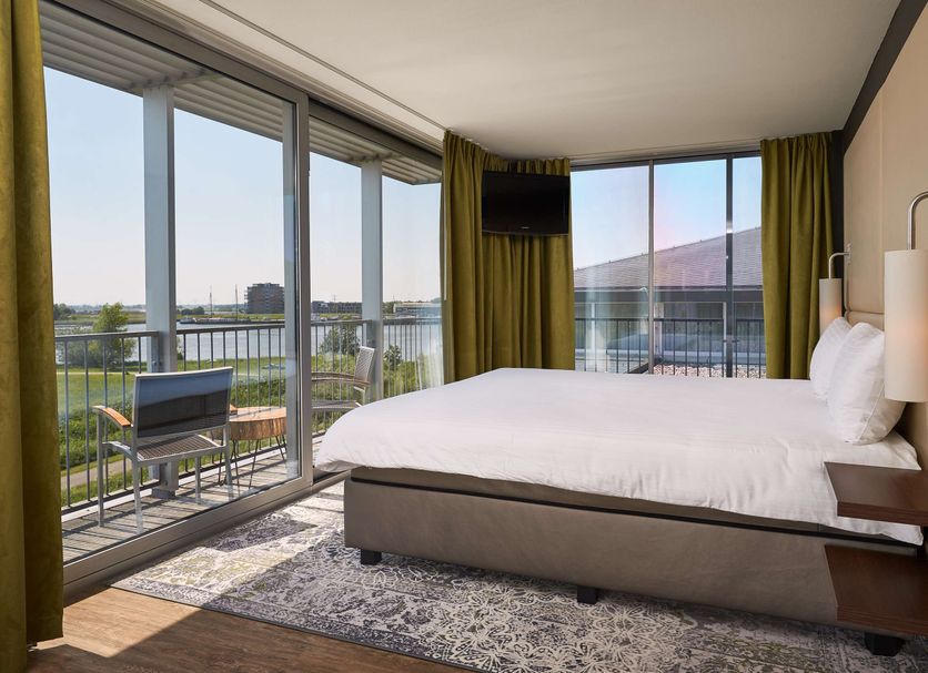 Van Der Valk Hotel Ara, Zwijndrecht room with bed and balcony overlooking the water