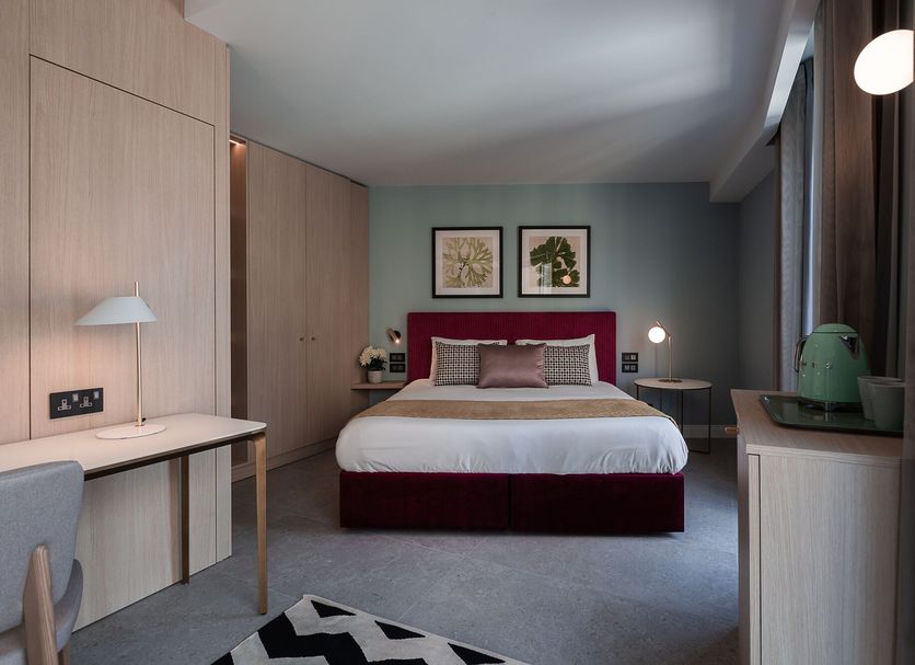 123 Mainstreet Boutique Hotel in St. Julian's guest room with king bed, desk, and large window