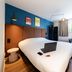 ibis Paris Alésia Montparnasse 14ème room with double bed, desk, window seat and blue accent wall in Paris