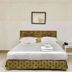 Lopburi Inn Hotel in Lop Buri guest room with bed, bedside table, and framed wall art