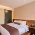 James Joyce Coffetel San Yuan LI Station Guangzhou guest room with king bed and warm wood accents