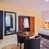 Rhogem Hotel in Takoradi guest room with king bed, round table, chairs, and wardrobe with mirror