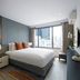 Somerset Rama 9 Bangkok guest room with king bed, city view window, and modern desk in Bangkok