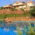 Kadambavanam Ethnic Village Resort in Madurai with hillside villas above a blue swimming pool