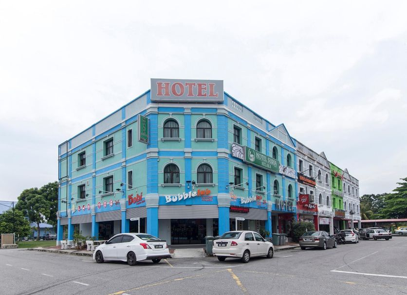 Hotel Suria Malaqa in Malacca, blue corner hotel exterior with parked cars