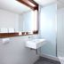 Campanile Grenoble Sud - Seyssins bathroom with sink, mirror, and glass shower enclosure in Seyssins