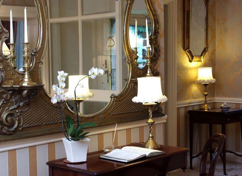 Killiane Castle Country House & Farm in Wexford, ornate hallway with mirror, lamp and orchids