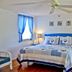 Night Swan Intracoastal B&B in New Smyrna Beach guest room with blue bedding, ceiling fan, and hardwood floors