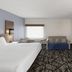 La Quinta Inn & Suites by Wyndham Atlanta Roswell guest room with bed, sofa, desk and TV