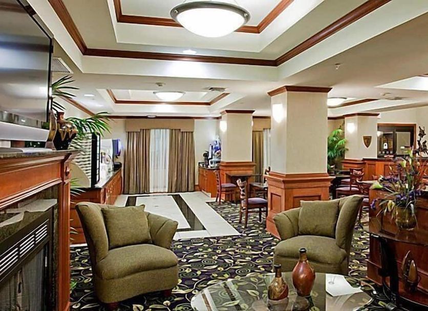 Holiday Inn Express & Suites Ada by IHG lobby with seating area and wood-paneled decor in Ada