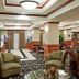 Holiday Inn Express & Suites Ada by IHG lobby with seating area and wood-paneled decor in Ada