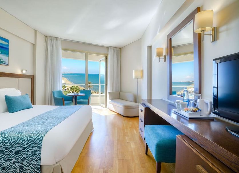 Golden Bay Beach Hotel Larnaca room with sea view, balcony, and bedside seating