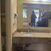 Somatel Goodlettsville bathroom vanity with sink, mirror, hair dryer, and hanging clothes rack