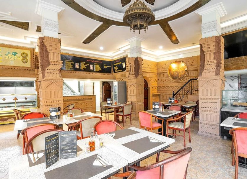 Hotel Casablanca City Center in Casablanca restaurant with carved columns, tables, and ceiling fan