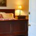 Bailey House in Annapolis Royal: a cozy bedroom with a wooden bed, lamp, and framed wall art