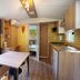 Camping Il Boschetto Di Piemma in San Gimignano: cabin interior with kitchen, dining table and forest view