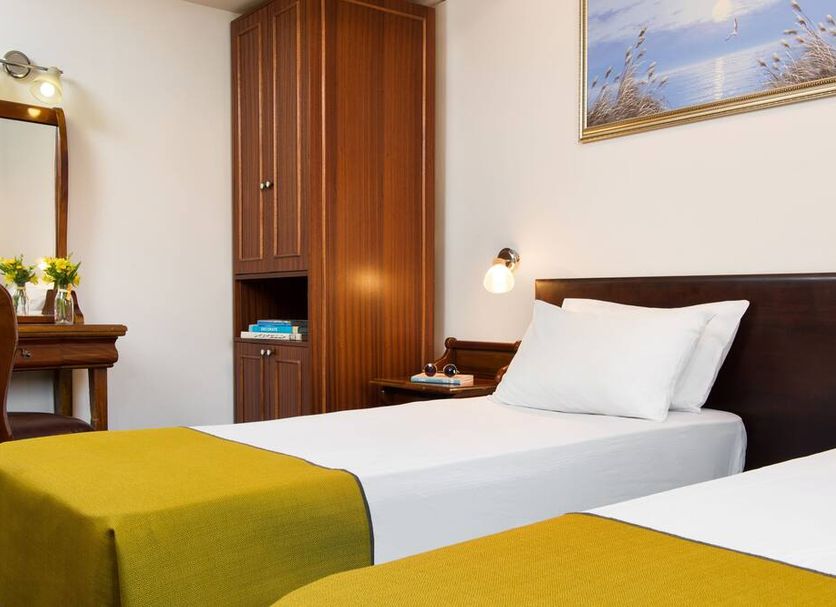 Sun City Hotel in Tel Aviv guest room with two single beds, desk, mirror, and wardrobe