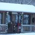 Evening Shade River Lodge & Cabins in Chimney Rock, snow-covered cabin porch with wreaths and railing