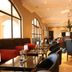 Velmore Hotel & Spa in Pretoria dining room with black tables, arched windows, and red banquettes