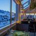 Hotel Toggenburg in Wildhaus dining room with mountain views through large windows at dusk